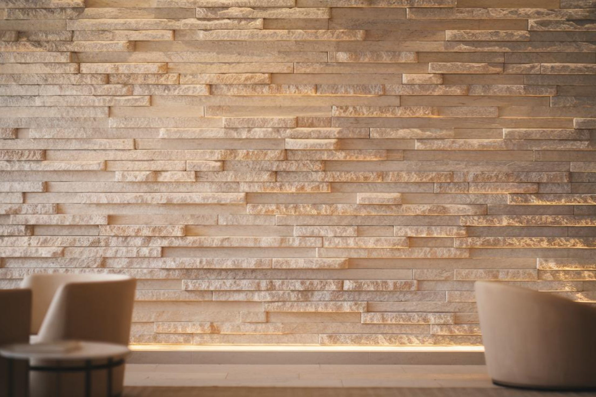 A soft-focus, full-width background image showcasing a luxurious interior space with a stunning natural stone wall cladding feature